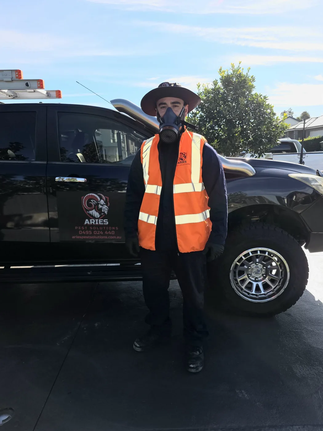 Owner of Aries Pest Solutions in uniform beside the signwritten work ute, ready for a residential pest control job in South West Sydney